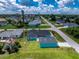 Aerial view of the property featuring a turquoise exterior, well-maintained lawn, and the surrounding neighborhood at 9457 Heartwellville Ave, Englewood, FL 34224
