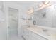 Bathroom featuring double vanity, tiled shower, and decorative mirror at 9457 Heartwellville Ave, Englewood, FL 34224