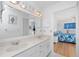 Bright bathroom with double sinks, large mirror, and access to the bedroom at 9457 Heartwellville Ave, Englewood, FL 34224