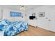 White bedroom with blue accents, a ceiling fan, and wood-look floors at 9457 Heartwellville Ave, Englewood, FL 34224