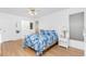 Bright bedroom featuring a blue patterned bedspread, ceiling fan, and ample natural light at 9457 Heartwellville Ave, Englewood, FL 34224
