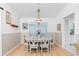 Bright dining room with a chandelier over a table with six chairs and wood floors at 9457 Heartwellville Ave, Englewood, FL 34224