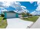 Side view of a charming turquoise home featuring a bright white garage and concrete driveway at 9457 Heartwellville Ave, Englewood, FL 34224