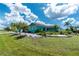 Charming turquoise home featuring a neatly manicured lawn, a rock garden, and lush landscaping at 9457 Heartwellville Ave, Englewood, FL 34224