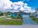Charming turquoise home featuring a well-maintained front yard with lush landscaping and a spacious driveway at 9457 Heartwellville Ave, Englewood, FL 34224