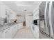 Bright, open kitchen with white cabinets, granite counters, and stainless steel appliances at 9457 Heartwellville Ave, Englewood, FL 34224