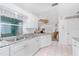 White kitchen with granite countertops, stainless sink, and open view to the living room at 9457 Heartwellville Ave, Englewood, FL 34224