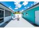 Outdoor patio featuring white Adirondack chairs, a chiminea, and turquoise painted home exterior at 9457 Heartwellville Ave, Englewood, FL 34224