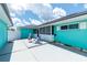 Backyard patio featuring white Adirondack chairs, a chiminea, and turquoise painted home exterior at 9457 Heartwellville Ave, Englewood, FL 34224