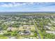 Aerial view of a property in a residential area with mature trees and landscaping, enclosed by a fence for privacy at 10263 Waterford Ave, Englewood, FL 34224