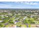 Aerial view of a property in a quiet neighborhood featuring lush trees, a well-maintained lawn, and peaceful surroundings at 10263 Waterford Ave, Englewood, FL 34224