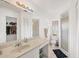 Well-lit bathroom with a large mirror, walk-in shower, and an adjacent walk-in closet at 10263 Waterford Ave, Englewood, FL 34224