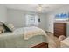 Comfortable bedroom with light walls, wood-look floors, and a mounted flat-screen television at 10263 Waterford Ave, Englewood, FL 34224