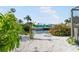 Scenic backyard canal view showcasing tropical landscaping and a glimpse of waterfront living at 1030 Haste Ln, Englewood, FL 34223