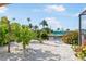 Landscaped backyard overlooking canal, featuring a birdhouse and lush tropical foliage at 1030 Haste Ln, Englewood, FL 34223