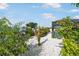 Backyard canal view featuring tropical foliage and access to a pool area at 1030 Haste Ln, Englewood, FL 34223