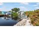 Waterfront dock with boat lift and canal access, surrounded by lush landscaping at 1030 Haste Ln, Englewood, FL 34223
