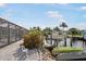 Waterfront home featuring a boat lift, dock, lush landscaping, and screened lanai for enjoying outdoor living at 1030 Haste Ln, Englewood, FL 34223