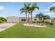Charming home featuring a manicured lawn and tropical landscaping at 1030 Haste Ln, Englewood, FL 34223