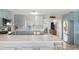 Bright kitchen with island, marble countertops, stainless appliances, and stylish light blue cabinetry at 1030 Haste Ln, Englewood, FL 34223
