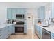 Charming kitchen with stainless steel appliances, stylish blue cabinets, and marble countertops at 1030 Haste Ln, Englewood, FL 34223