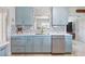 Modern kitchen featuring marble countertops, stainless steel appliances, and stylish blue cabinetry at 1030 Haste Ln, Englewood, FL 34223