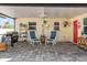 Inviting covered patio with stylish pavers, comfortable seating, and a convenient outdoor grill area at 1030 Haste Ln, Englewood, FL 34223