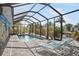 The screened pool area offers sun loungers, lush landscaping, and access to the canal at 1030 Haste Ln, Englewood, FL 34223