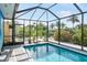 The screened pool area offers privacy, features tropical landscaping, and a tranquil outdoor experience at 1030 Haste Ln, Englewood, FL 34223