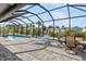 The screened patio has a sparkling pool, sun loungers, dining area, and serene views of the water at 1030 Haste Ln, Englewood, FL 34223