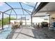 Spacious screened patio includes a grill, comfortable seating and views of the surrounding yard at 1030 Haste Ln, Englewood, FL 34223