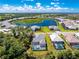 Aerial view of home with pool, lake view, and lush landscaping at 11044 Hogan Cir, Englewood, FL 34223