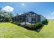 Expansive backyard featuring a screened-in pool, well-manicured lawn, and vibrant landscaping at 11044 Hogan Cir, Englewood, FL 34223