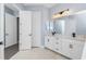 Bathroom with white cabinets, double sinks, and tiled floors at 11044 Hogan Cir, Englewood, FL 34223