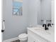 Powder room featuring a marble-top vanity with matte black fixtures and stylish grey walls at 11044 Hogan Cir, Englewood, FL 34223