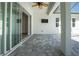 Covered patio with gray pavers, outdoor ceiling fan, and wall-mounted TV creating an outdoor living space at 11044 Hogan Cir, Englewood, FL 34223