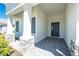 Stylish front porch featuring stone columns, gray shutters, and a modern entry door at 11044 Hogan Cir, Englewood, FL 34223