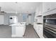 Open-concept kitchen featuring a center island, white cabinets, and views into the living area at 11044 Hogan Cir, Englewood, FL 34223