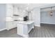 Well-appointed kitchen featuring white cabinetry, stainless steel appliances, a center island, and wood-look floors at 11044 Hogan Cir, Englewood, FL 34223