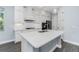 Bright kitchen featuring white cabinets, modern appliances, and a large island with a quartz countertop at 11044 Hogan Cir, Englewood, FL 34223