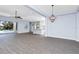 Bright living room with wood-look floors open to the kitchen and offering a view of the pool through sliding doors at 11044 Hogan Cir, Englewood, FL 34223