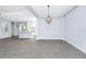 Spacious living area featuring wood-look floors and an elegant chandelier, connected to the modern kitchen at 11044 Hogan Cir, Englewood, FL 34223