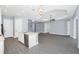 Open floor plan with modern kitchen, gray wood-look floors, and decorative lighting fixtures at 11044 Hogan Cir, Englewood, FL 34223