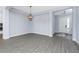 Open living space featuring wood-look flooring, a chandelier, and views into the front entry at 11044 Hogan Cir, Englewood, FL 34223
