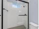 Walk-in shower with subway tile, dark hardware, and glass doors at 11044 Hogan Cir, Englewood, FL 34223