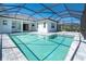 Refreshing screened-in pool with gray brick paver deck offering a private outdoor oasis at 11044 Hogan Cir, Englewood, FL 34223