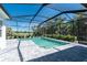 Inviting screened-in pool with pavers and lush landscaping providing a peaceful retreat at 11044 Hogan Cir, Englewood, FL 34223