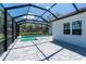Beautiful screened-in pool area featuring gray pavers and partial view of landscaped backyard at 11044 Hogan Cir, Englewood, FL 34223