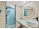 Sleek bathroom with a glass shower enclosure, blue tile, marble counters, and modern fixtures at 1401 S Mccall Rd # 205, Englewood, FL 34223