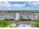 Condo building with private balconies, parking area, and outdoor lounging area with jacuzzi at 1401 S Mccall Rd # 205, Englewood, FL 34223